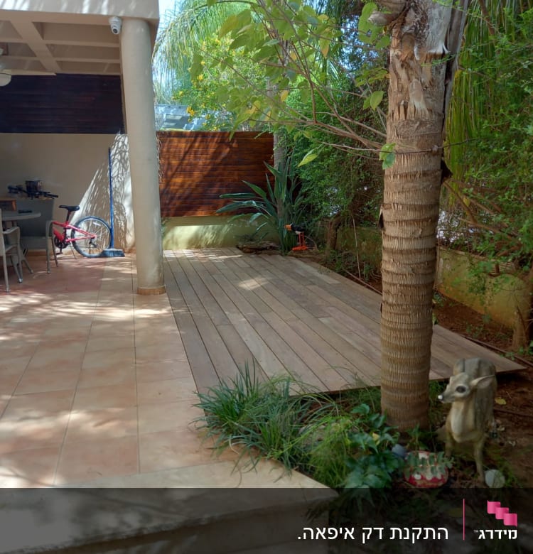 דק עץ בגינה עם צמחייה מסביב